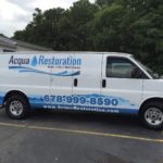 Aqua Restoration corporate wrap with windows, logos, and lettering.